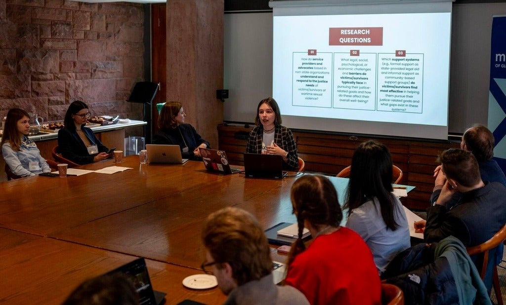 Student presenting to others around boardroom table