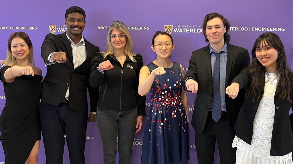 Engineering students and professor show off their iron rings