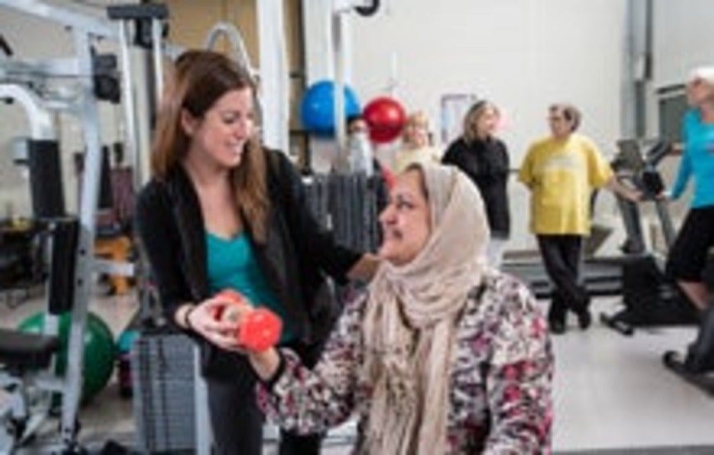 student helping woman with fitness training
