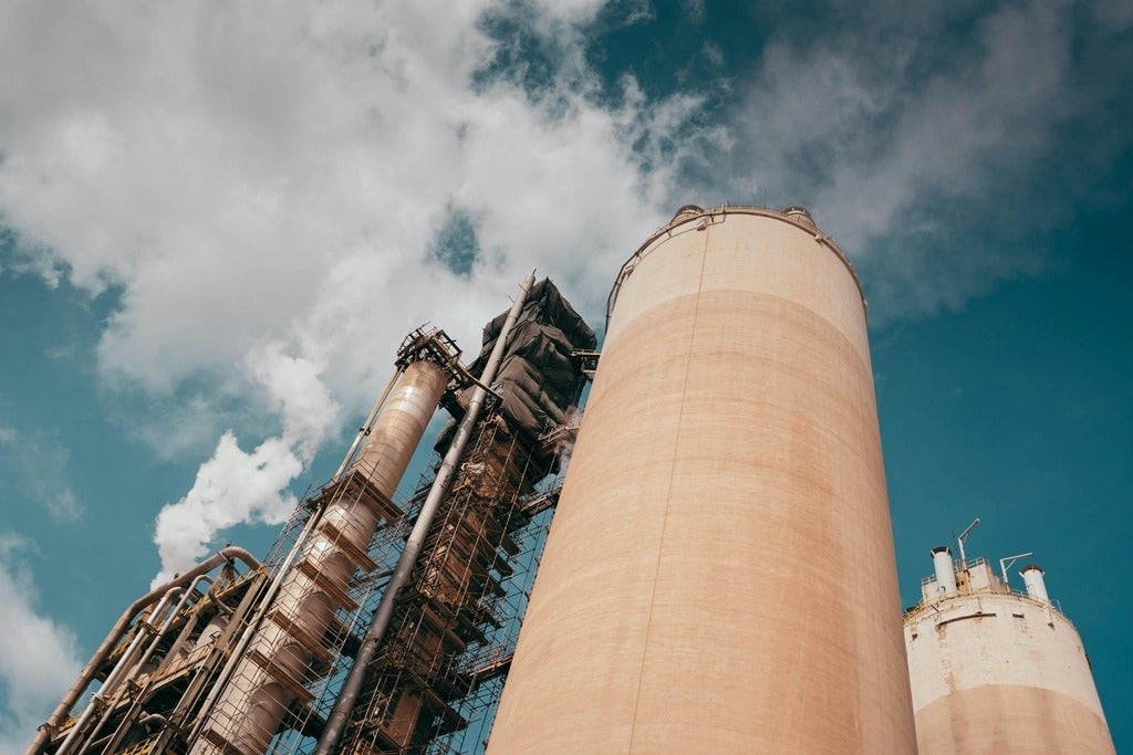 A view of smoke stacks with smoke coming out of them