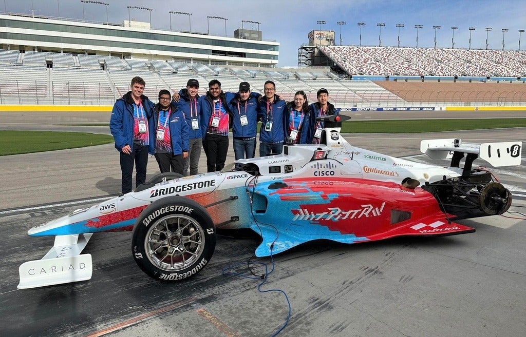 University of Waterloo students pose with their self-driving race car in Las Vegas.