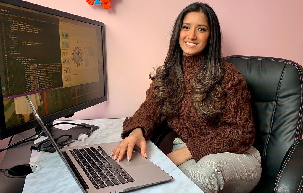 Sara Ibrahim sitting at her computer, looking at the children's story