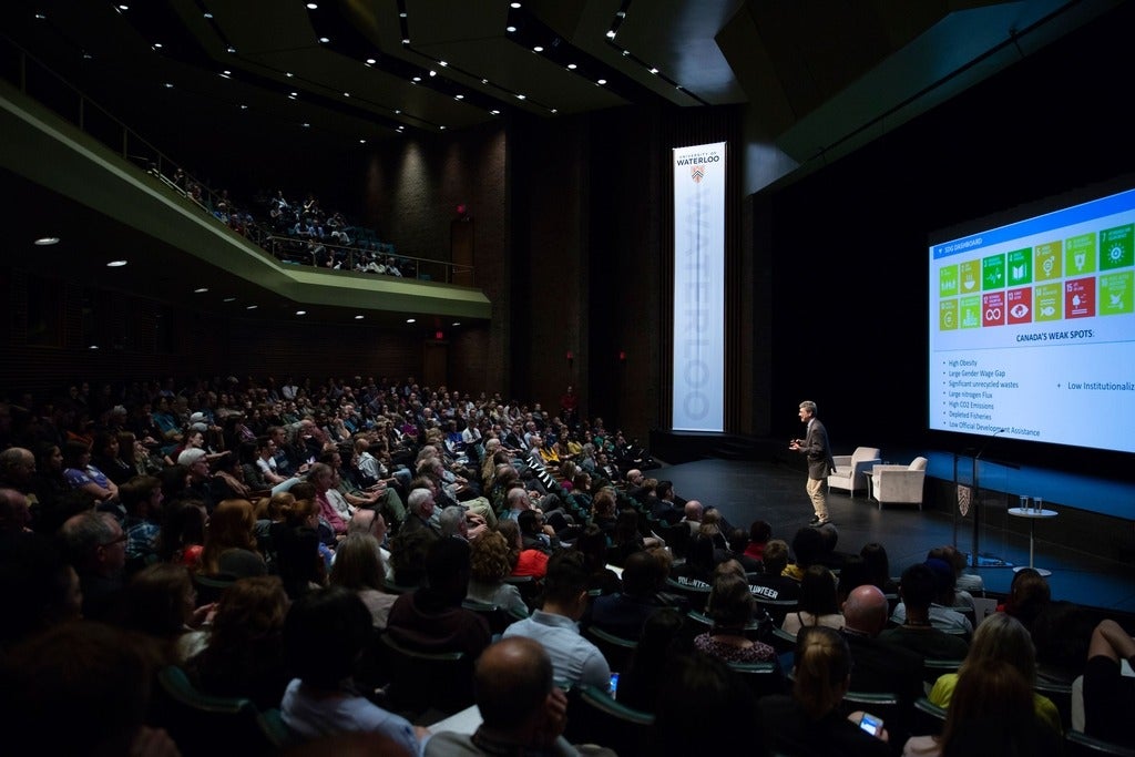 A large crowd of people gather in an auditorium