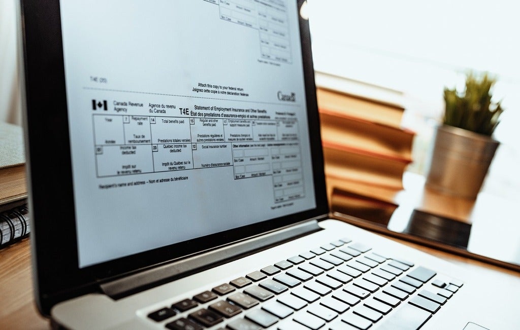 Close up of an open laptop with a section of a tax form visible on the screen