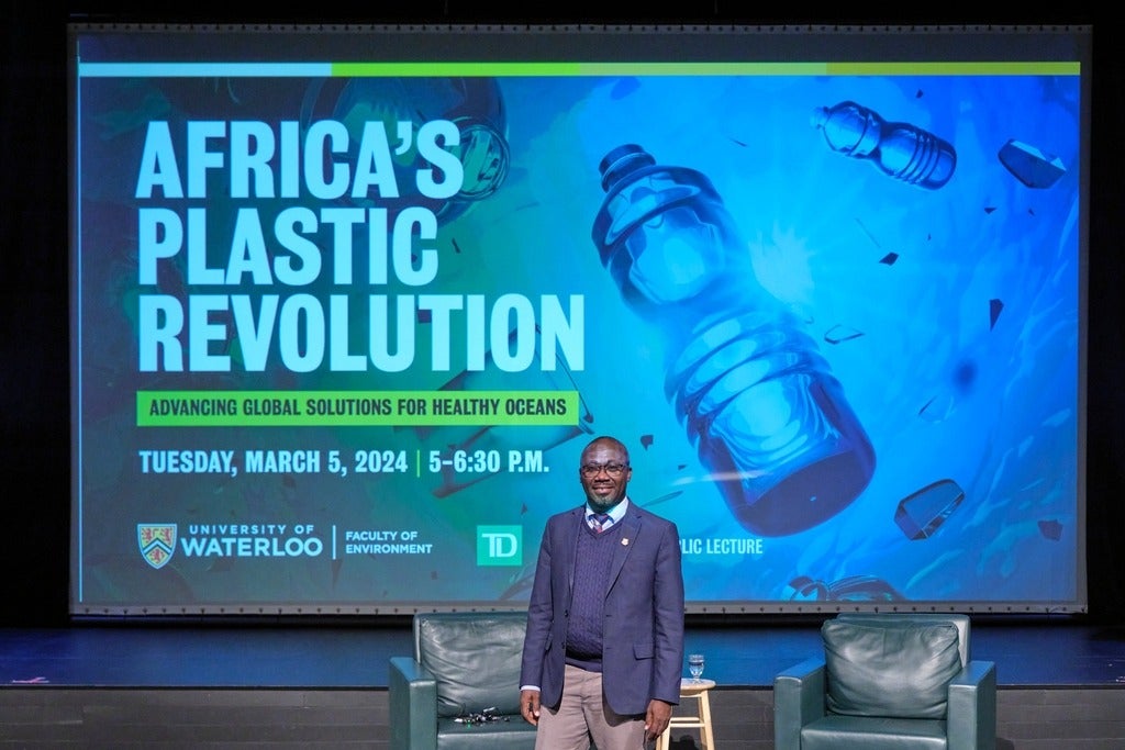 Dr. Denis Aheto on stage in front of "Africa's Plastic Revolution" backdrop. 