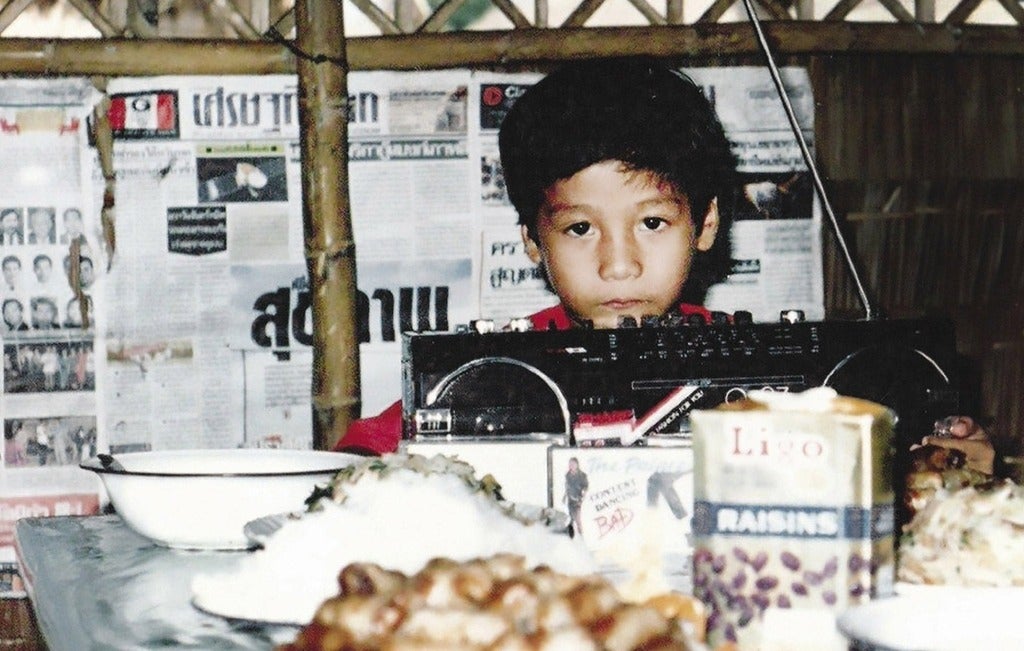 Archival photo of a young Vin Nguyen at his birthday part in a tent in a refugee camp