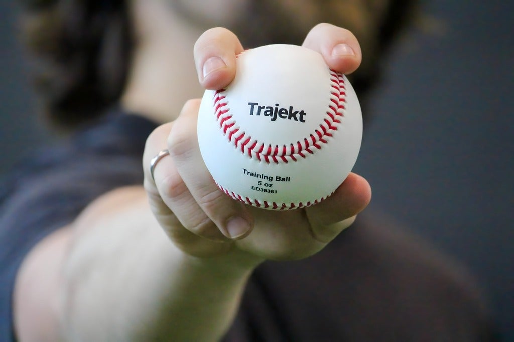 Person holds out a baseball with a fastball grip