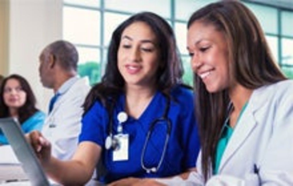 Health-care students looking at laptop