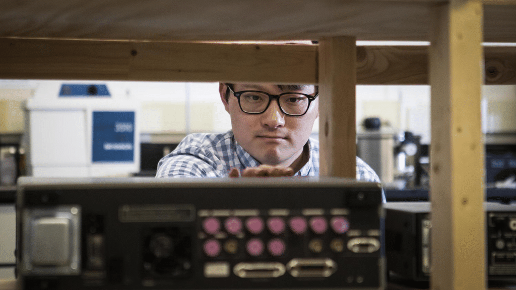 Adam Wei Tsen conducting research in the lab at IQC.