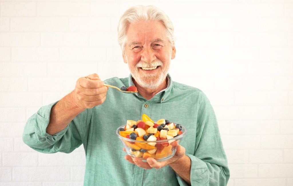 Older white man eats fruit salad