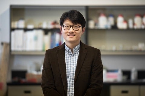Dr. Adam Wei Tsen standing in the middle of his lab