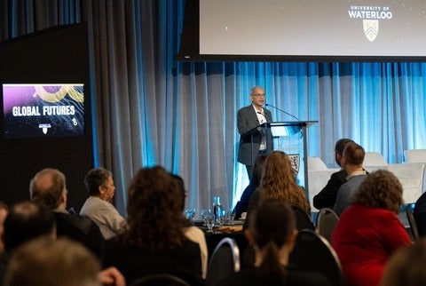 Vivek Goel addresses a large audience at the launch of Global Futures. He speaks from a podium on stage at Fed Hall.