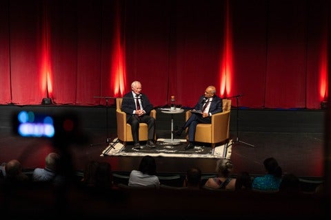 David Johnston and Vivek Goel seated on stage in discussion.