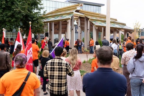 Vivek Goel addresses a large audience outside the Indigenous gathering space on the University of Waterloo campus