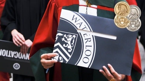Graduant in PhD regalia holds up diploma folder with Waterloo written on the cover
