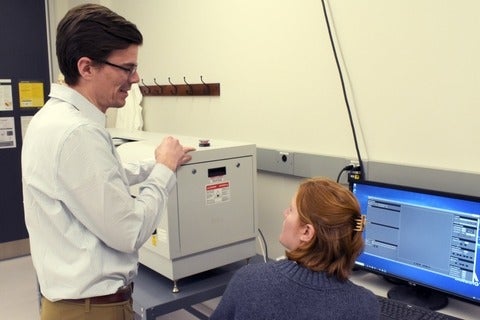 Two researchers discussing results from the microscope