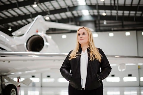 Suzanne Kearns stands in front of an airplane looking up