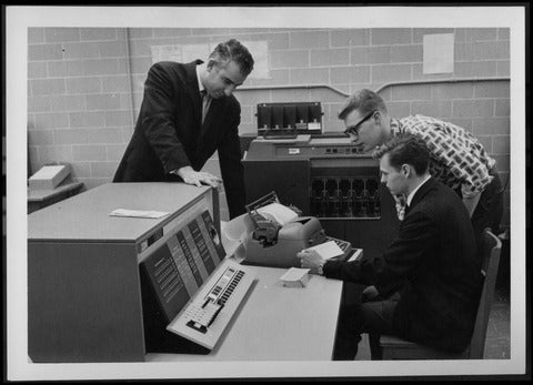 Professor Graham stands over a student working in the computer lab