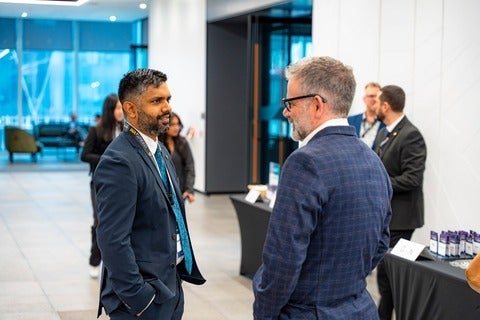 Aaron Pereira in mid-conversation with a man
