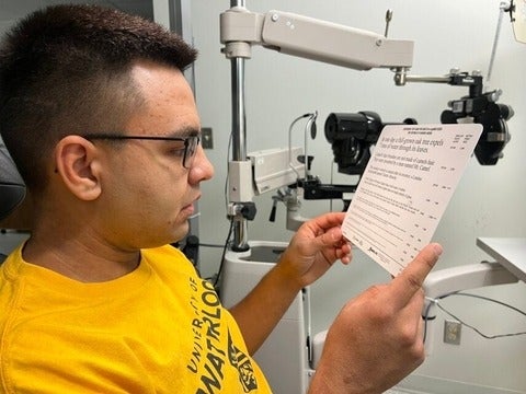 University of Waterloo Indigenous student, Jeremiah Hyslop, reading text on a standardized eye exam card