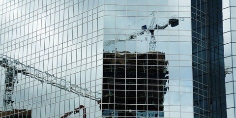 reflection of a crane in a high-rise building