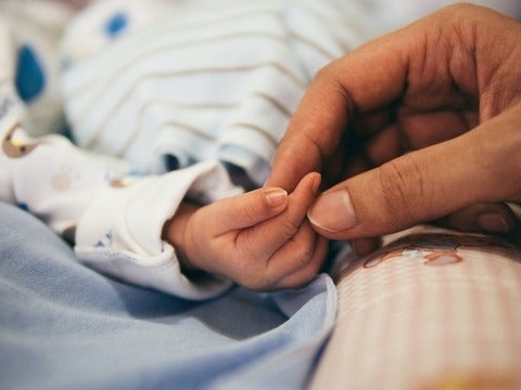 baby hand holding an adult hand