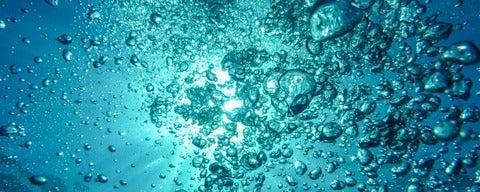 Underwater air bubbles rising up towards surface