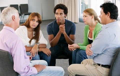 People sitting in a group listening to a group ther