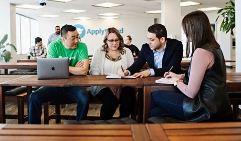 Martin and three employees meet around a table