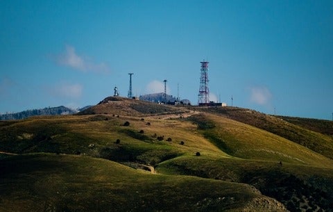 A hill with cellular towers in the distance