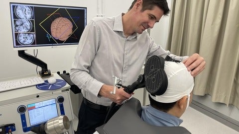 Ben Thompson fitting a device on a patient's head