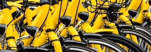 Multiple yellow bikes arranged in a row