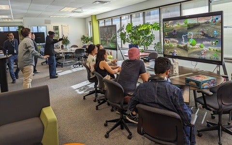 A group of members of the Games Institute playing video games on a large screen