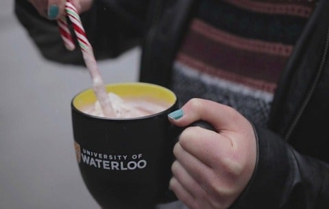 Candy cane stirring hot chocolate in UWaterloo mug
