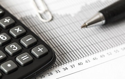 Calculator and pen laying on a graph printout