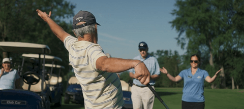 Older man celebrating with others on a golf course