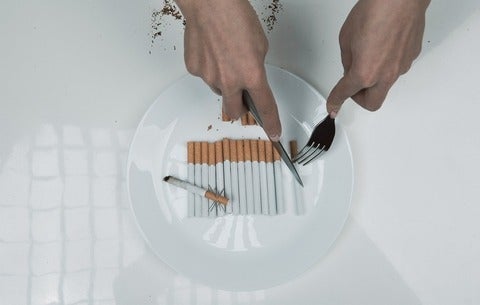 Images shoes hands cutting a plate of cigarettes
