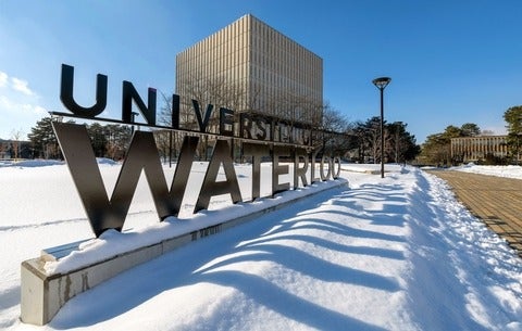 A photo of the University of Waterloo sign in front of Dana Porter library with snow on the ground