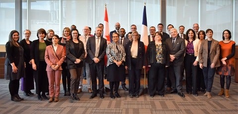 the delegation posing front of Canadian and French flags