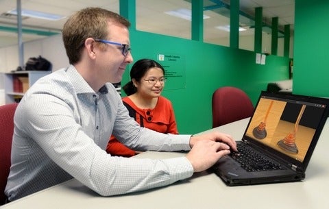Professor Christopher Batty with a coworker showing fluid simulations.