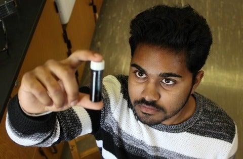 Duleeka Ranatunga examines a vial of hydrogel for use in cancer research.
