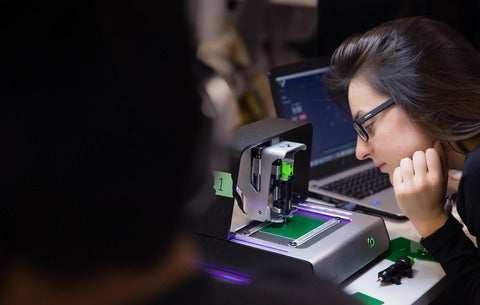 Girl watching as a circuit board is printed