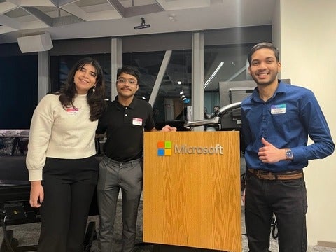 Undergraduate students standing at Microsoft podium in Toronto