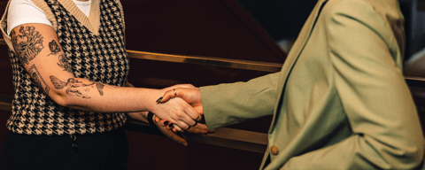 close up of two employees wearing business attire shaking hands