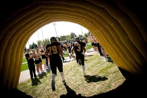 Football players run onto the field