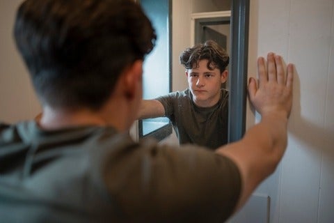 Male youth looking into mirror