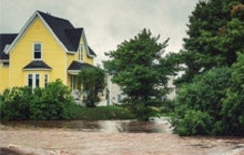 A fast moving, flooding river endangers homes