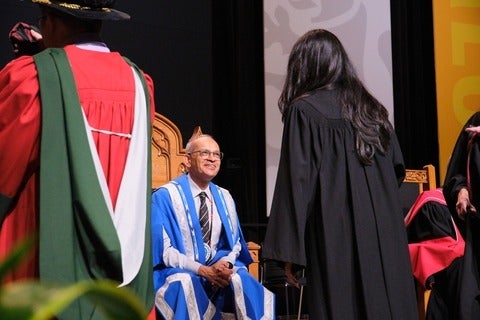President Goel smiles as he speaks to a graduate during convocation ceremony.