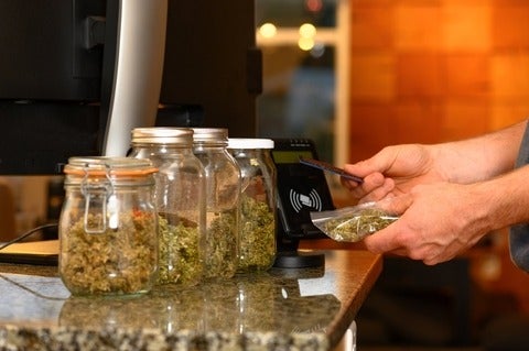 Someone paying by credit card for marijuana at a cannabis dispensary