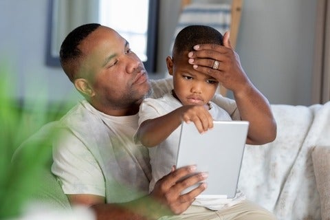 Father using online symptom checker to assess his ill son